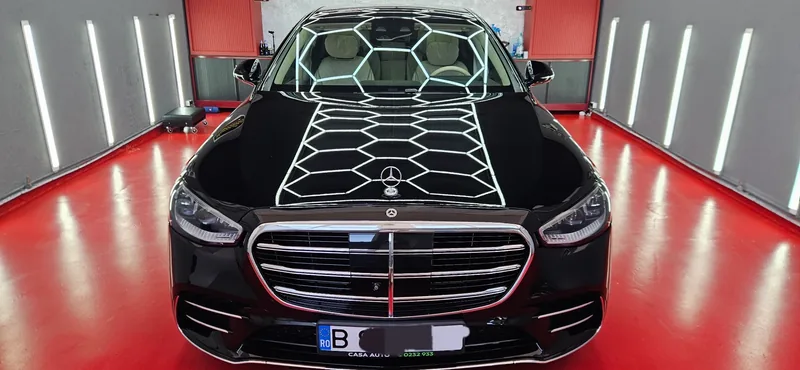 Mercedes negru cu reflexiile atelierului în lac